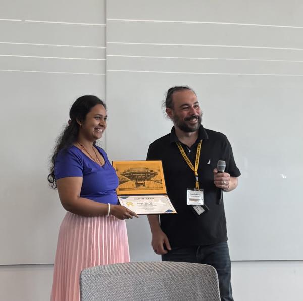 Maitreyee Ghosh (left) receives her prize from Petros Tzeferacos (U. Rochester)